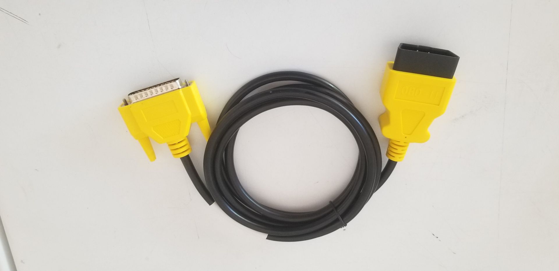 A yellow and black cable is sitting on a white surface.