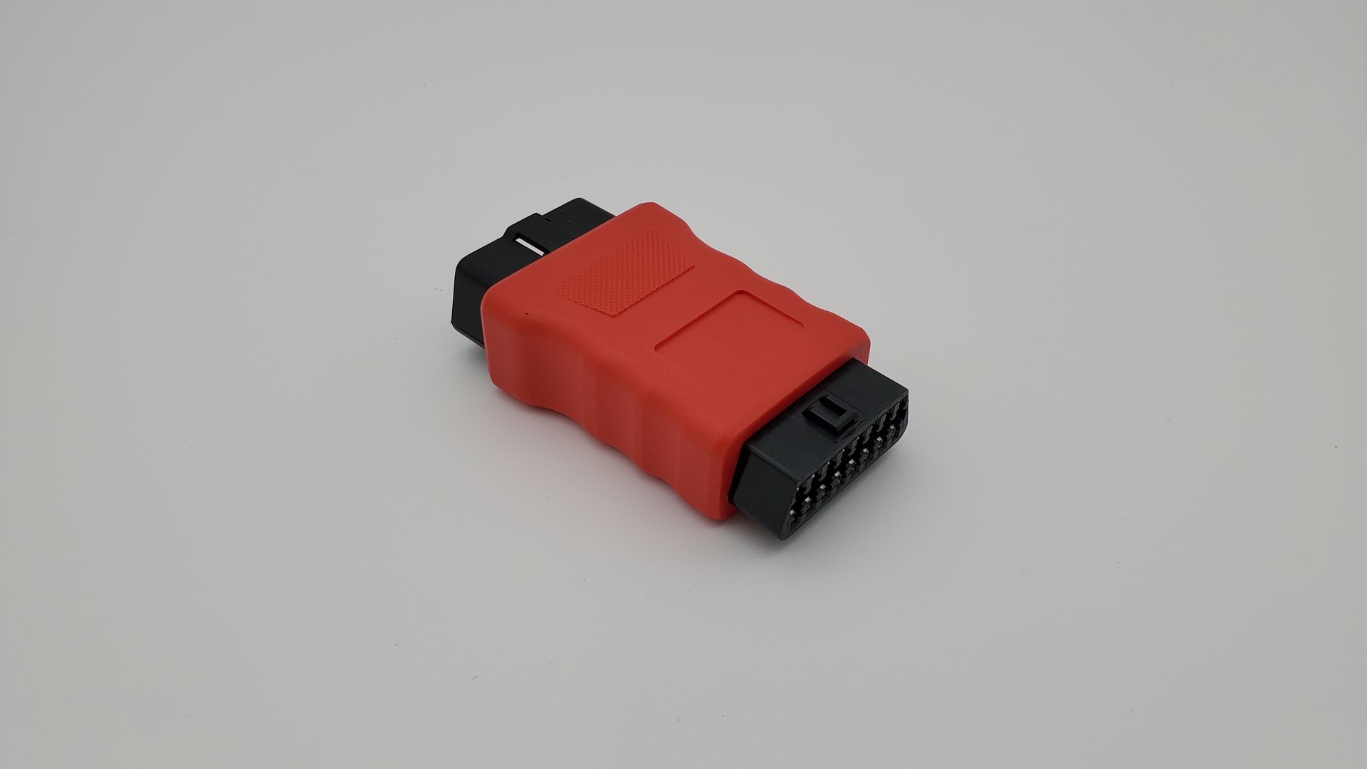 A red and black device is sitting on a white surface.