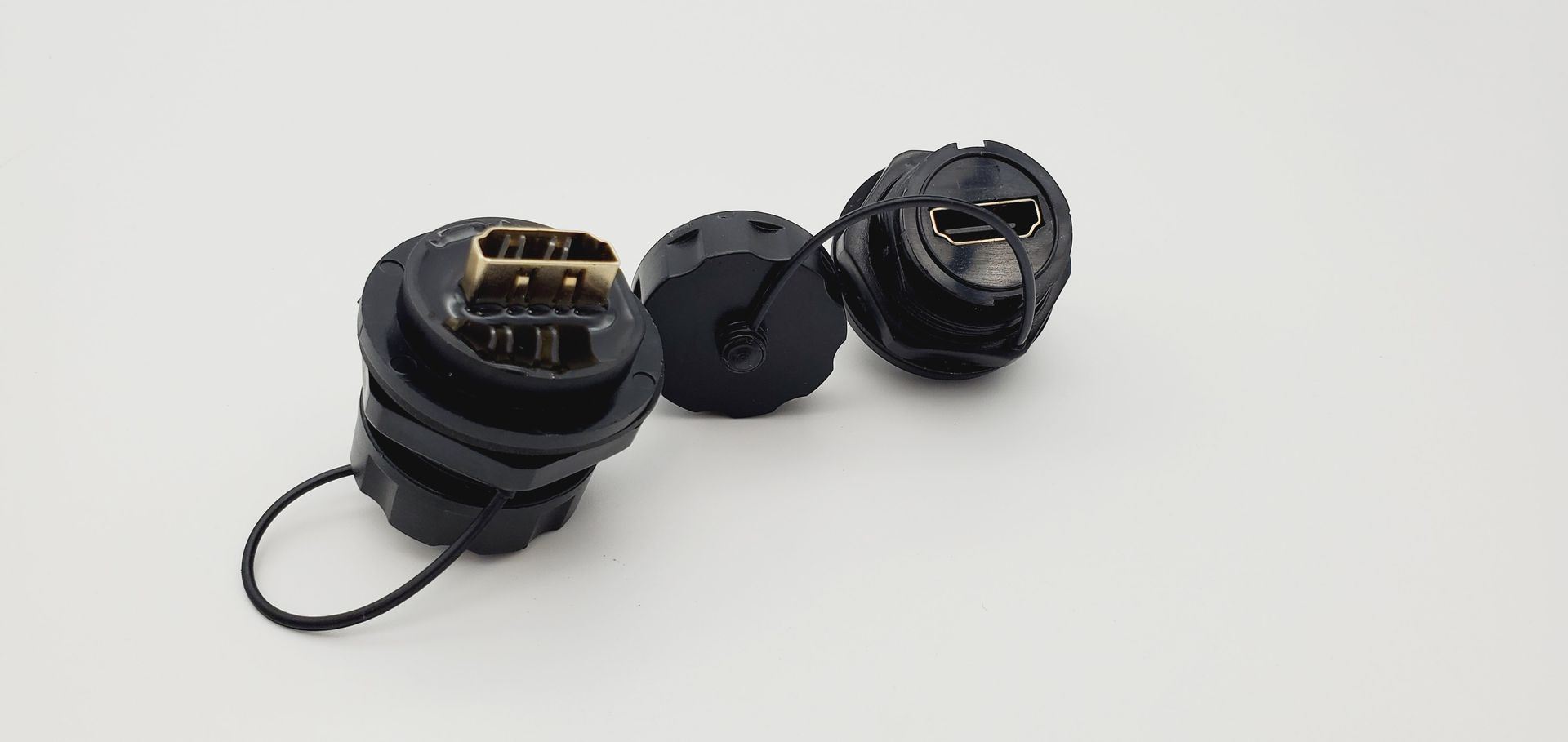 Three black connectors are sitting on top of each other on a white surface.