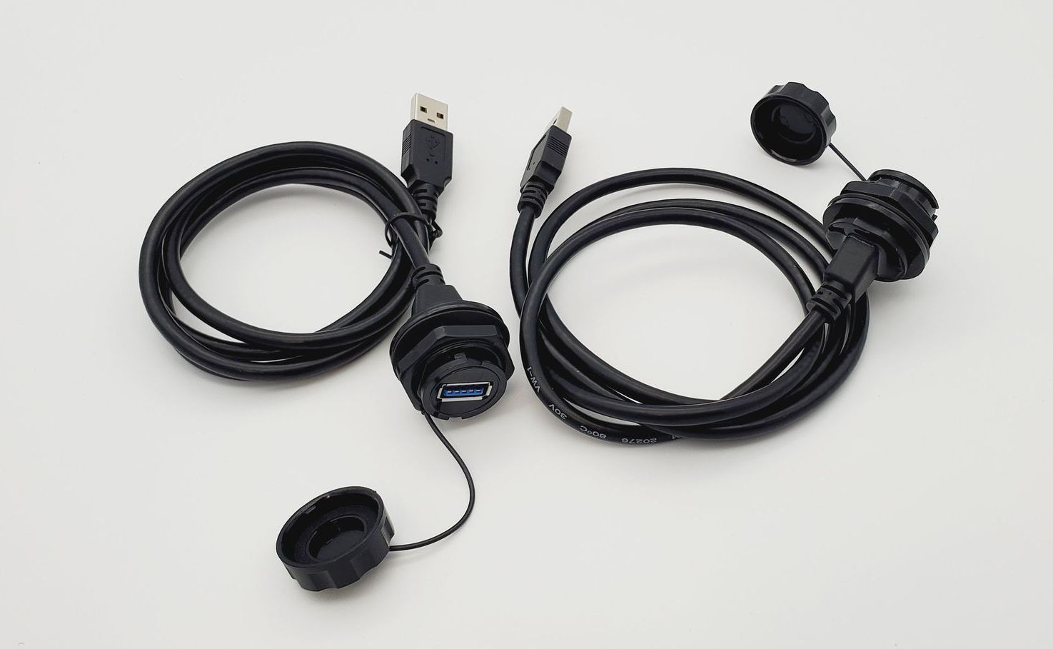 A pair of black usb cables with covers on them