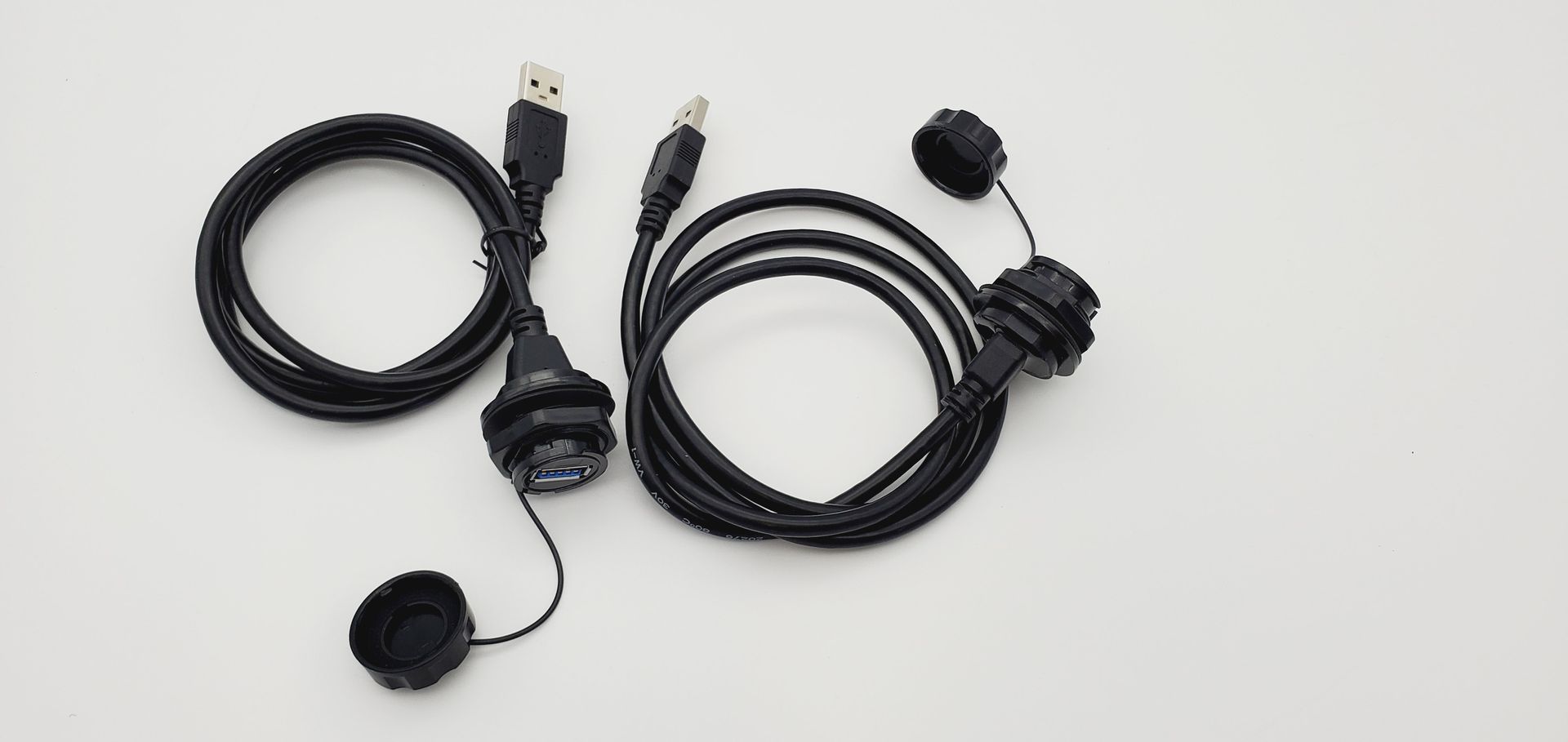 A bunch of black cables are laying on a white surface.