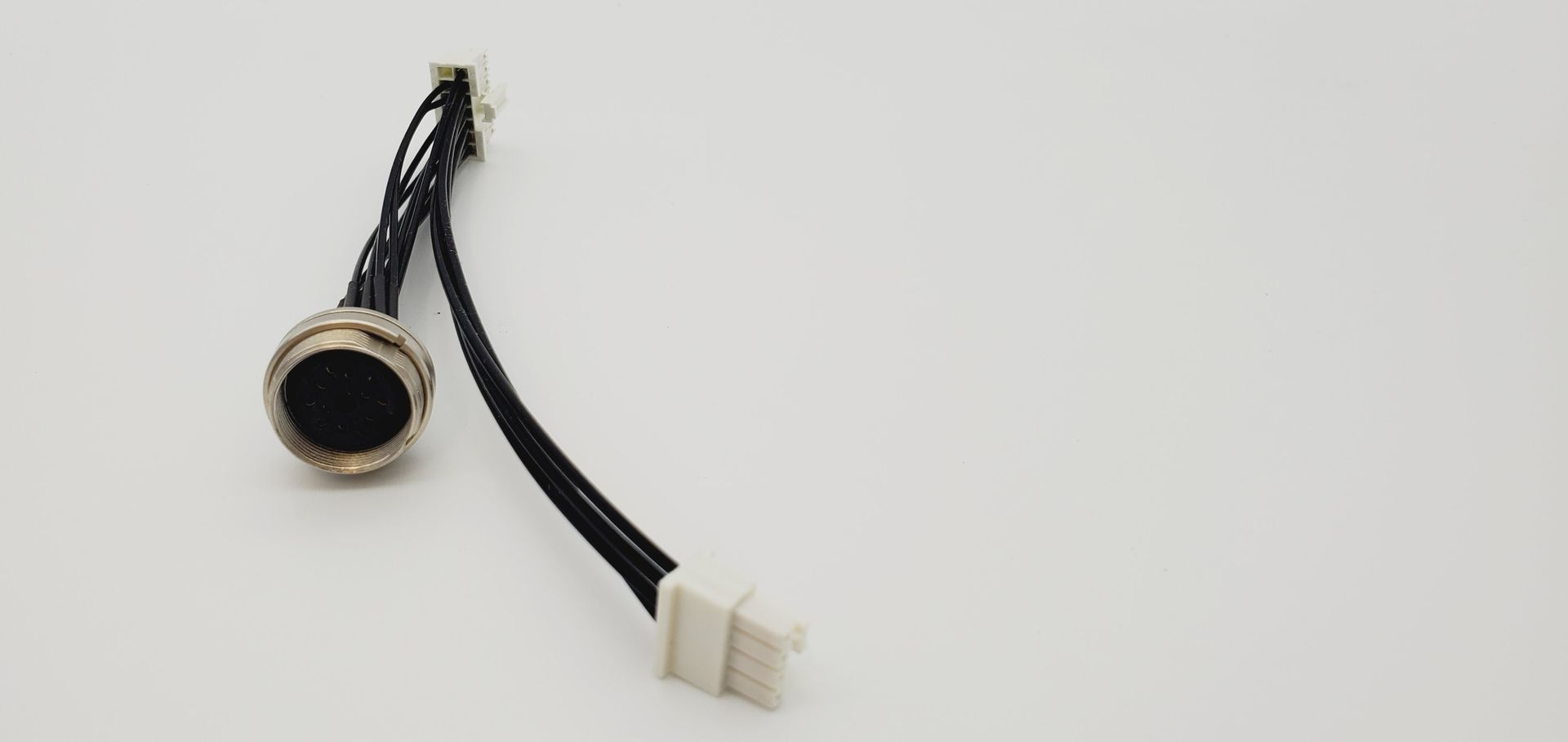 A close up of a microphone with two wires attached to it on a white surface.