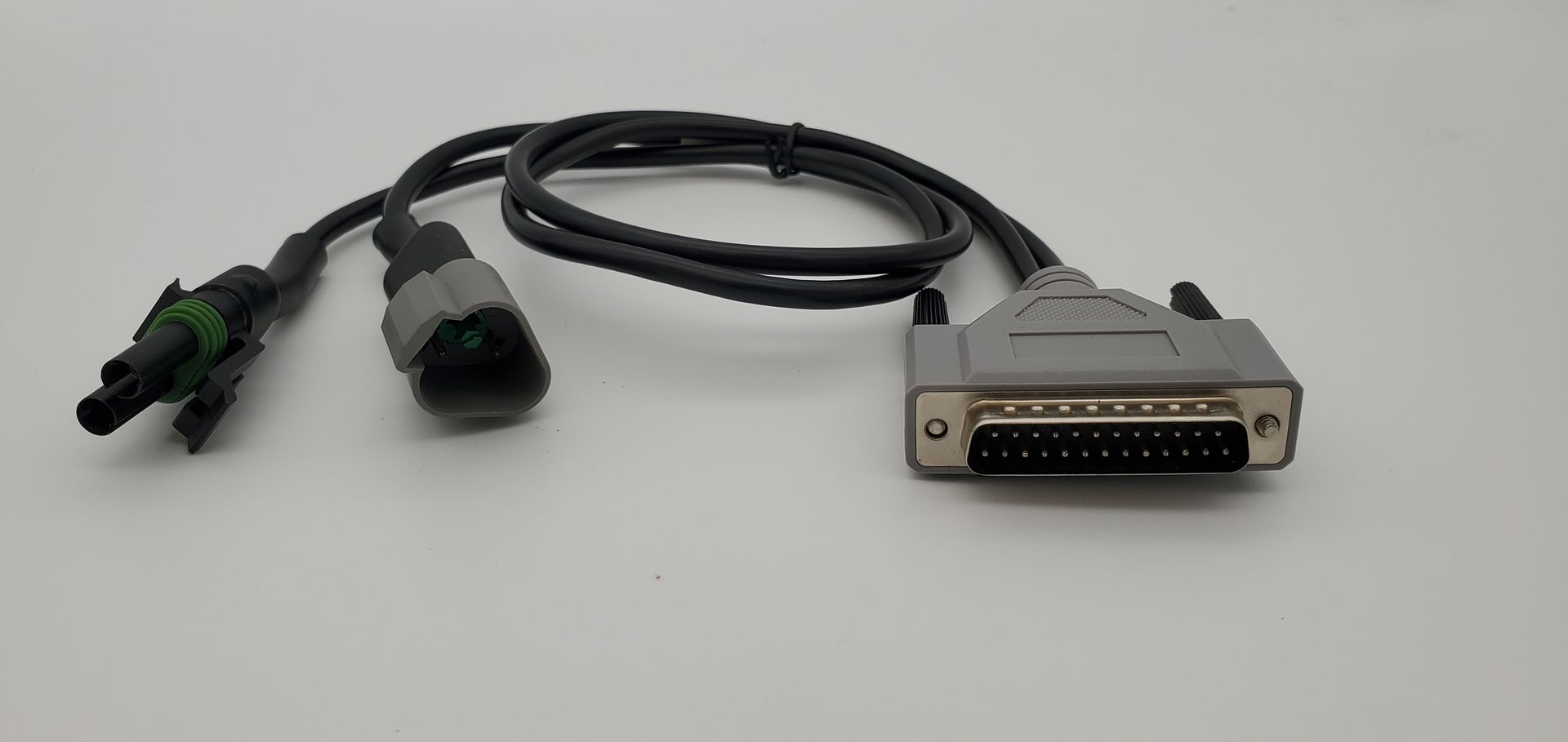 A cable with two plugs attached to it is sitting on a white surface.