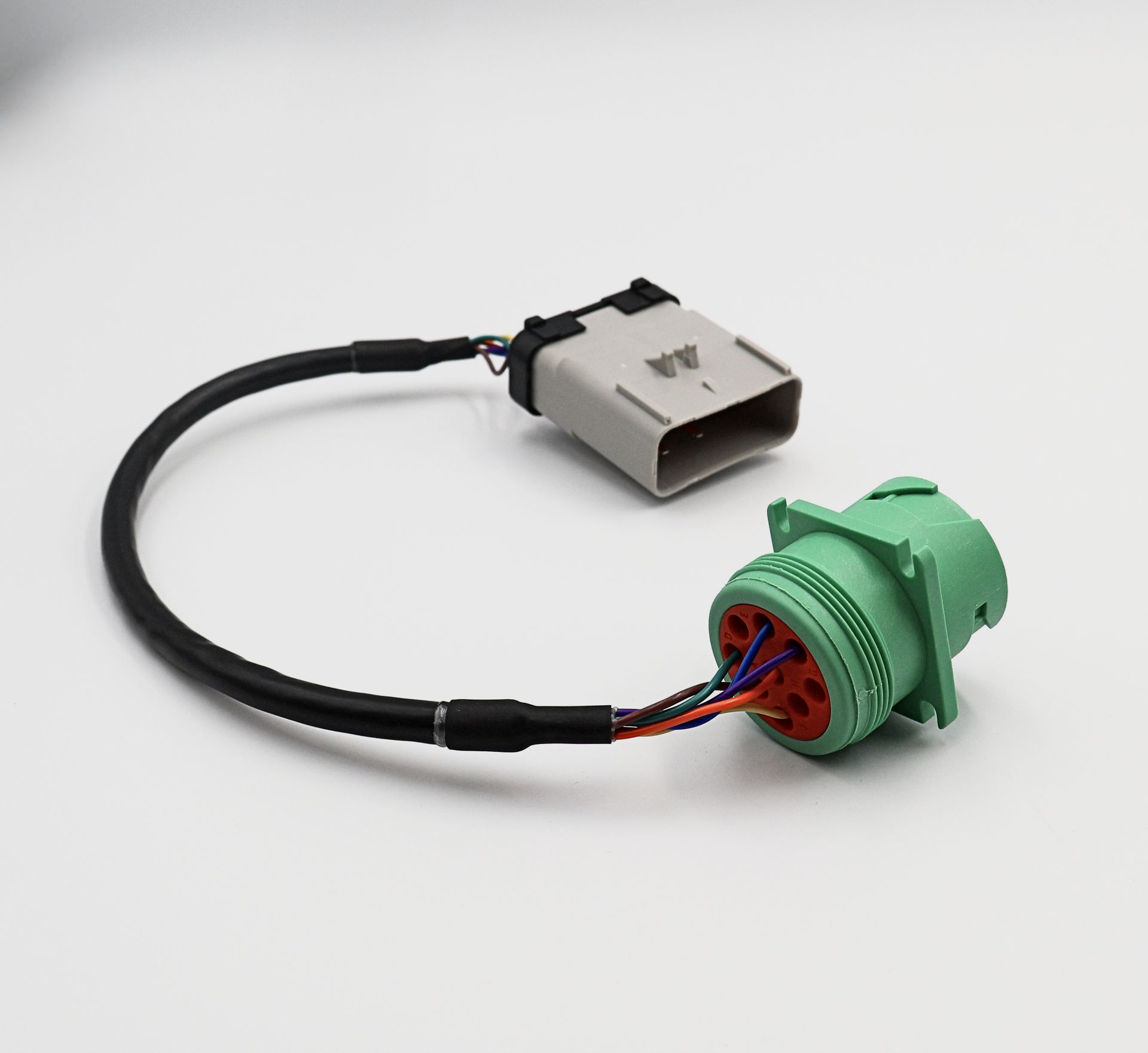 A green connector and a white connector are on a white surface.