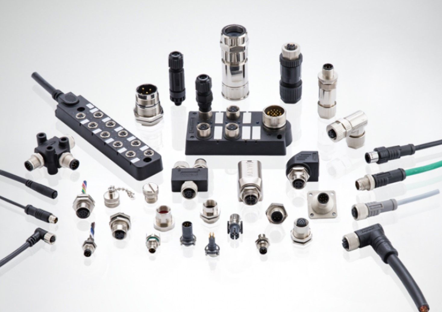 There are many different types of connectors and cables on the table.