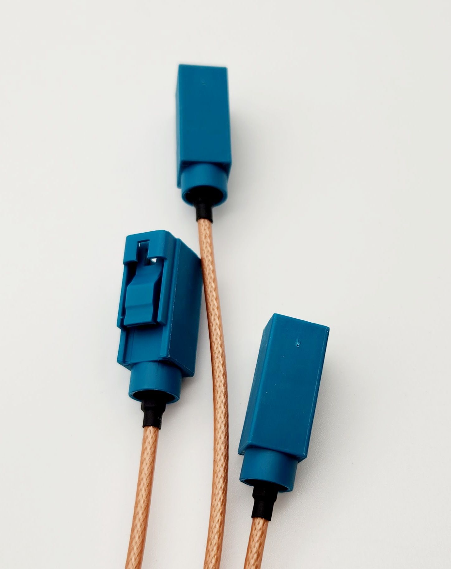 Three blue connectors with copper wires on a white surface