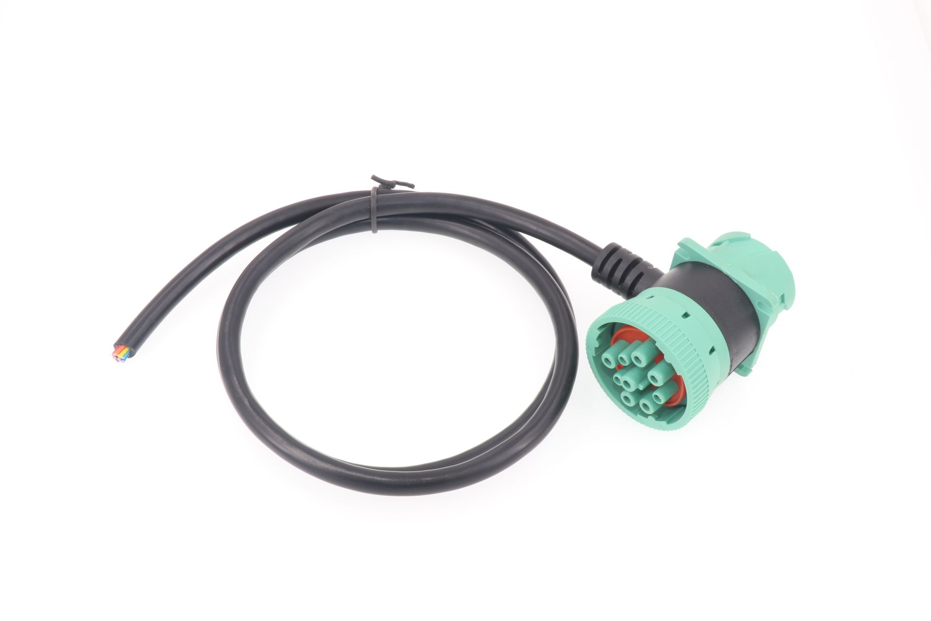 A close up of a cable with a green plug on a white background.