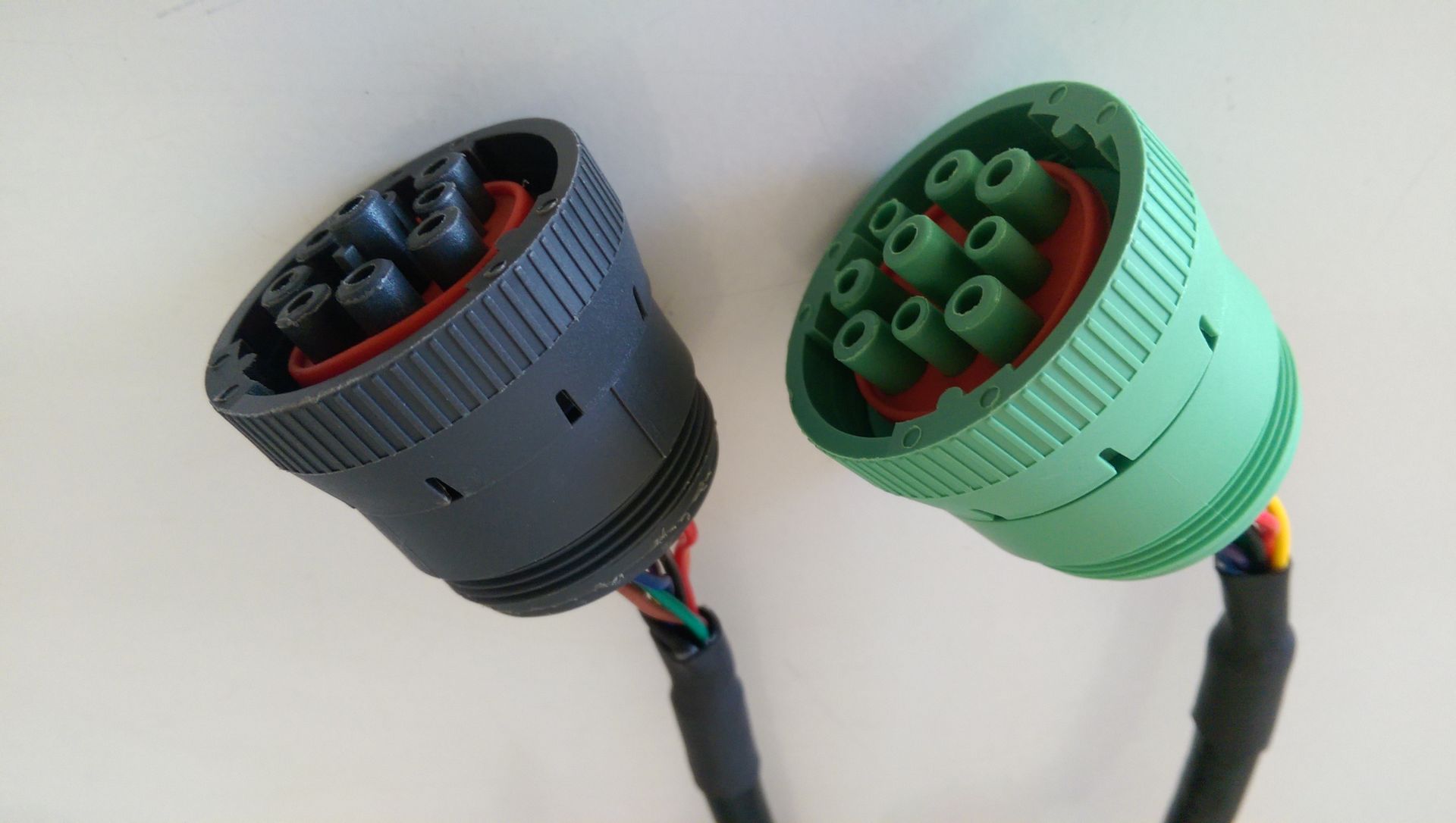 Two electrical connectors are sitting next to each other on a white surface.