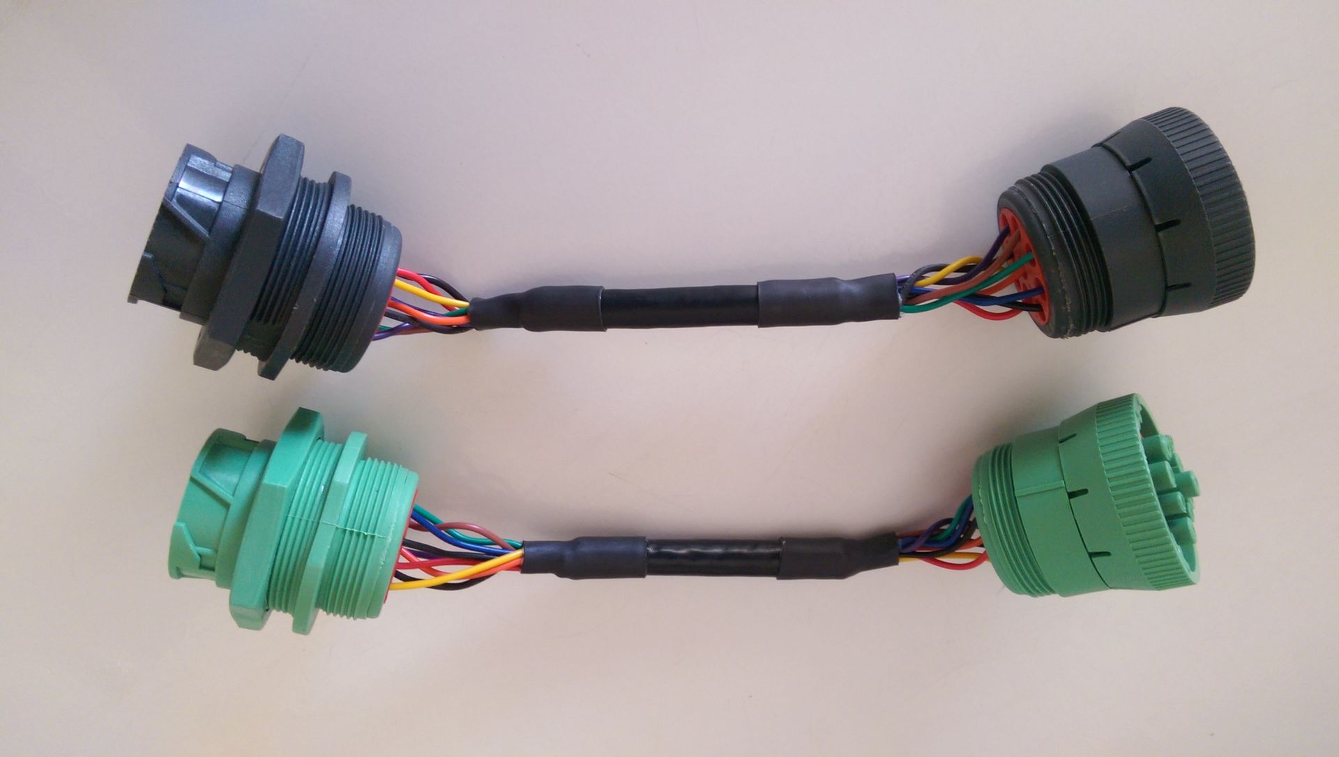 Two connectors with wires attached to them are sitting on a table.