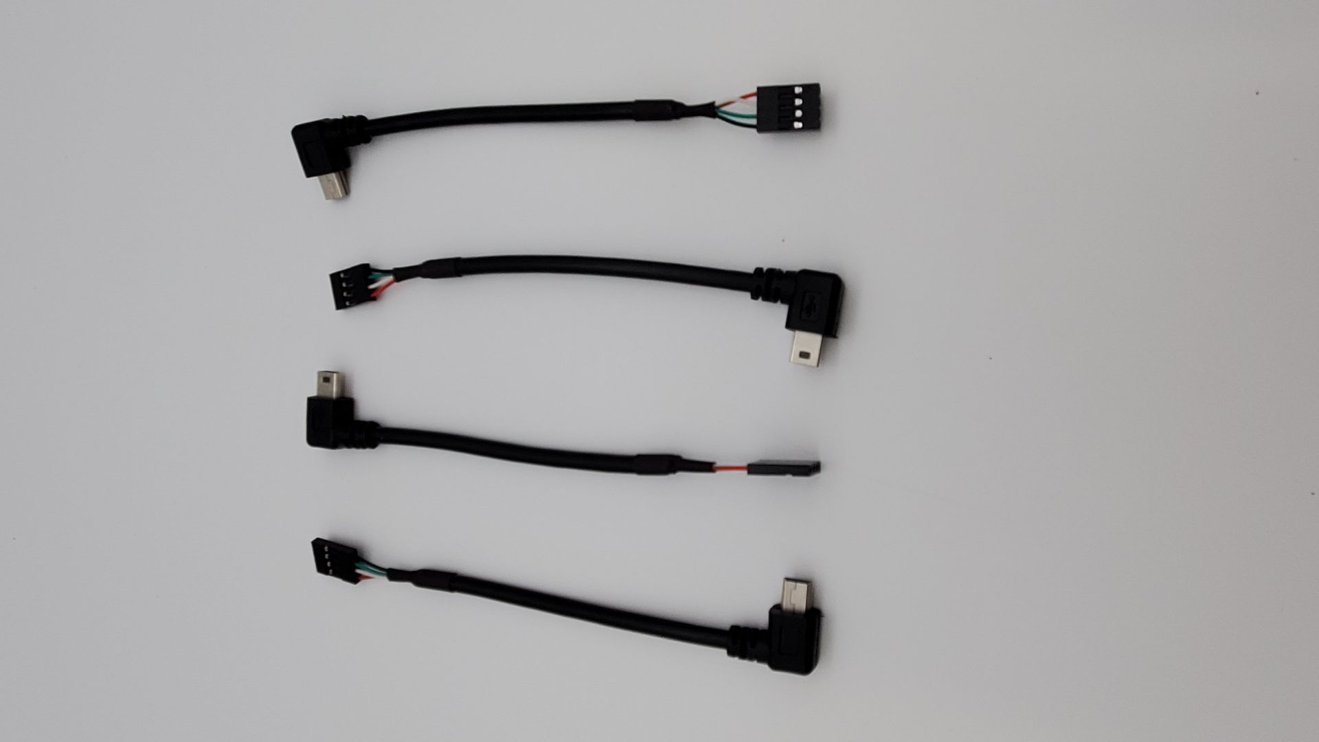 A bunch of cables are lined up on a white surface