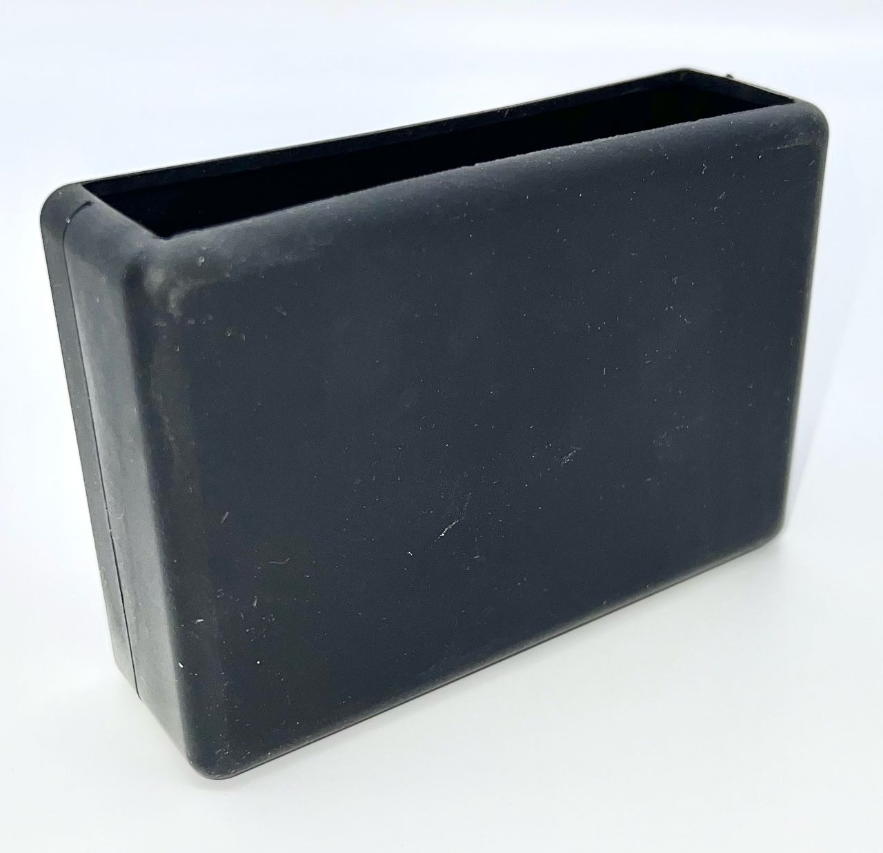 A black rectangular container is sitting on a white surface