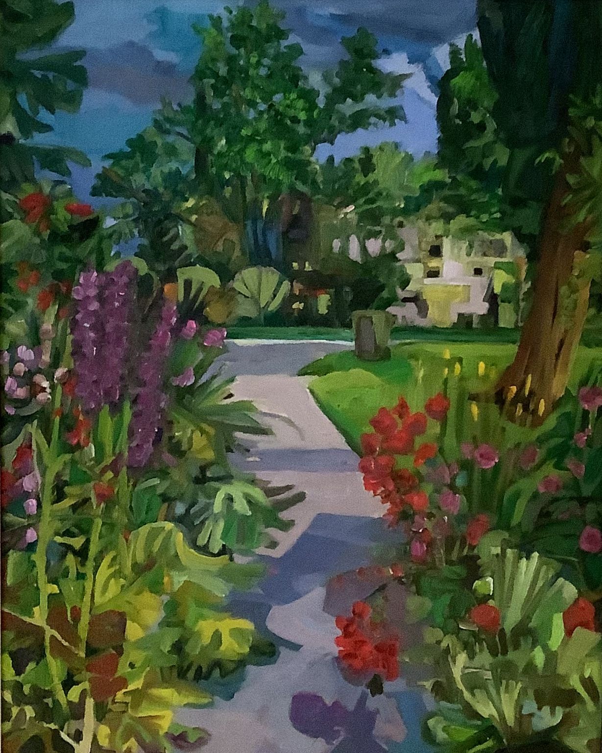 ©Karen Kulyk - Garden path lined with colorful flowers leads to a house; lush green trees and a cloudy sky.