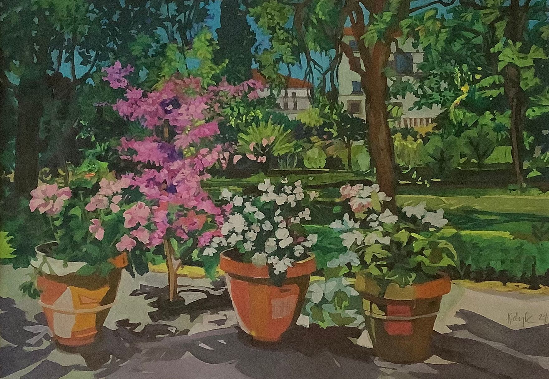 ©Karen Kulyk - Three potted flowers, pink and white, in front of a garden with buildings and trees in the background.