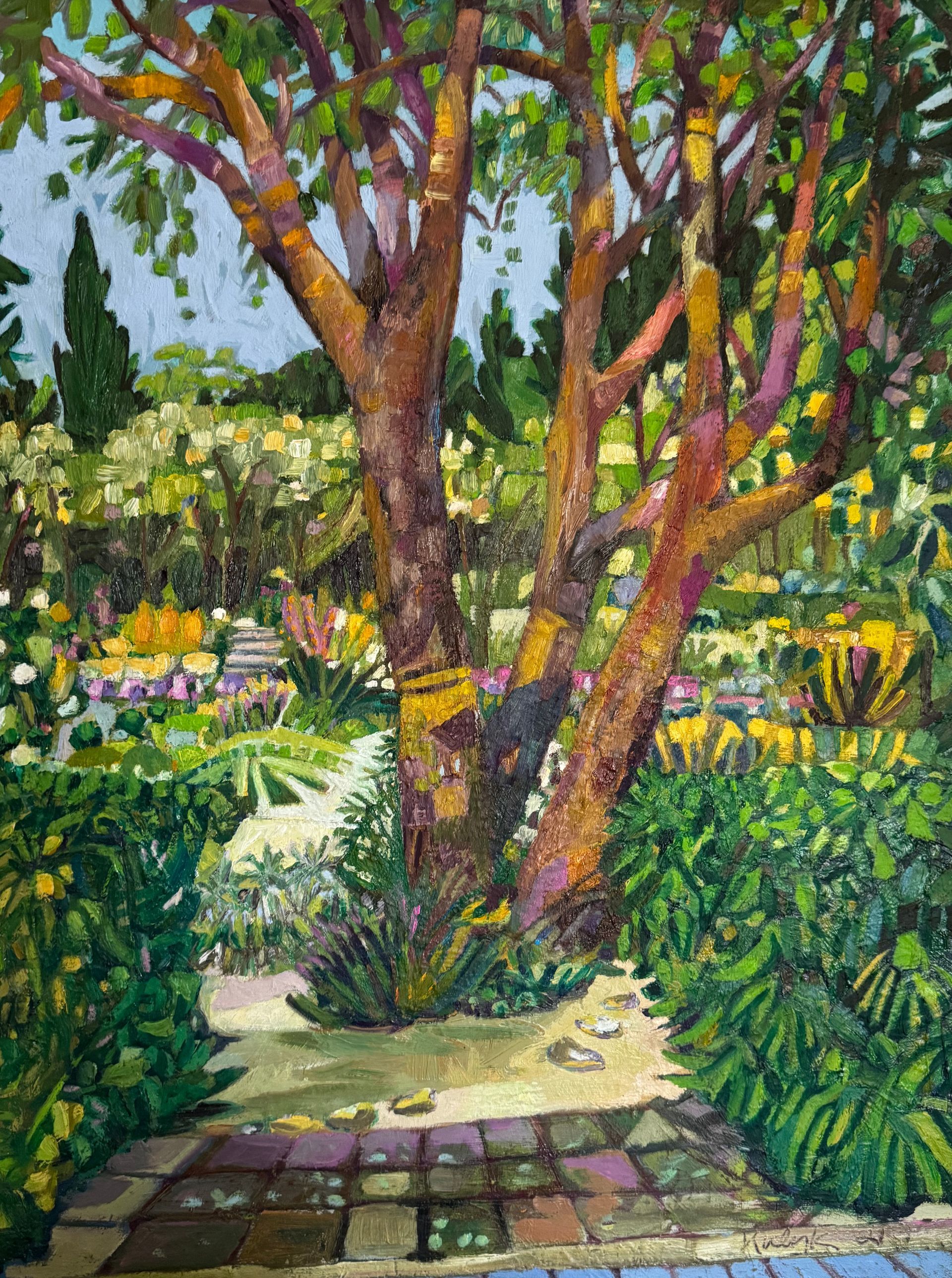 ©Karen Kulyk - A vibrant garden scene with a large tree in the foreground and colorful plants in the background.