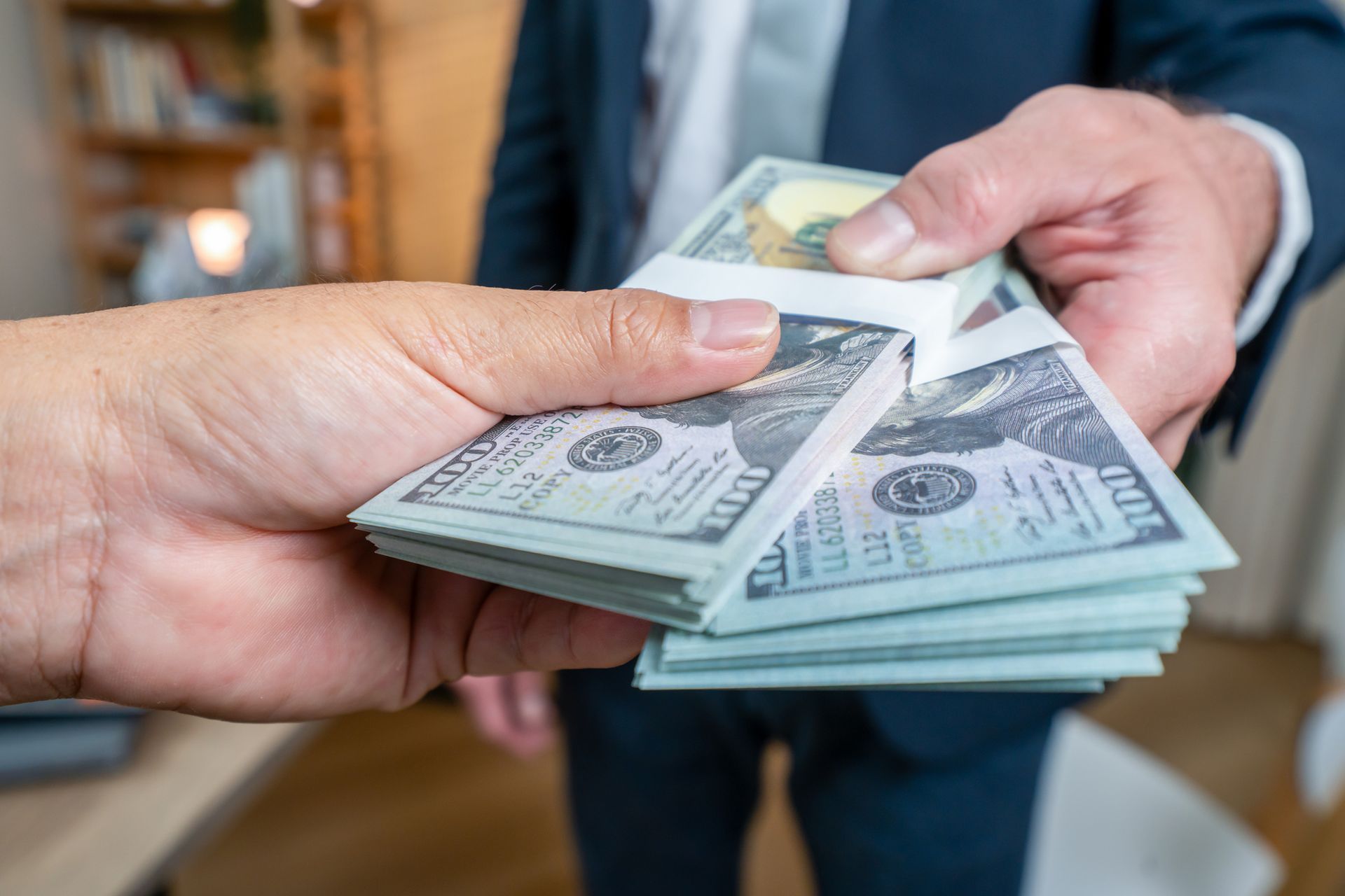 A hand gives money to another one.