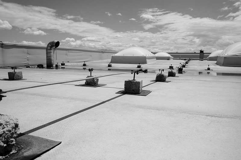 Une photo en noir et blanc d’un toit avec de nombreuses lucarnes.