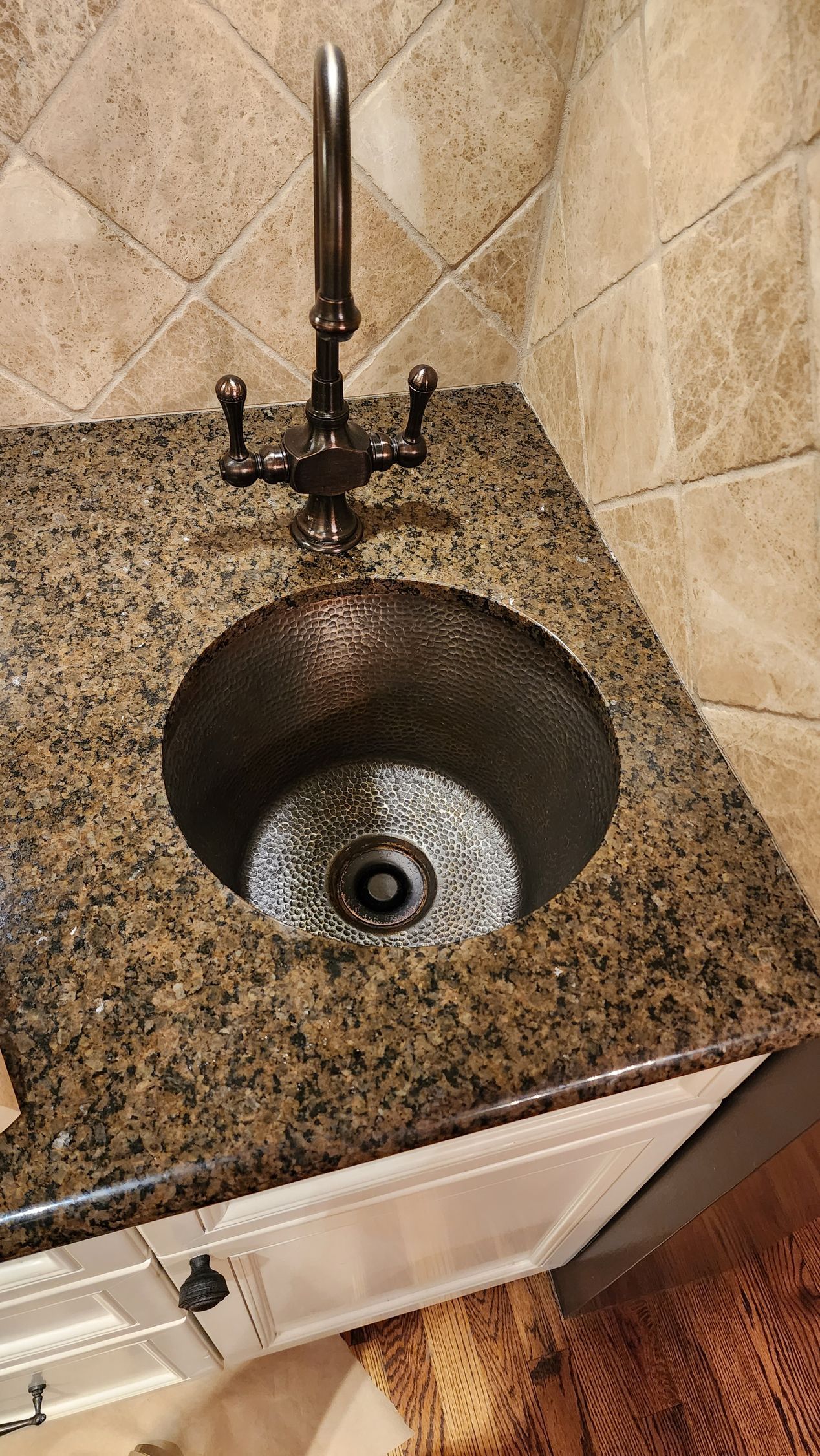 Bathroom sink with granite countertop and dark metal faucet
