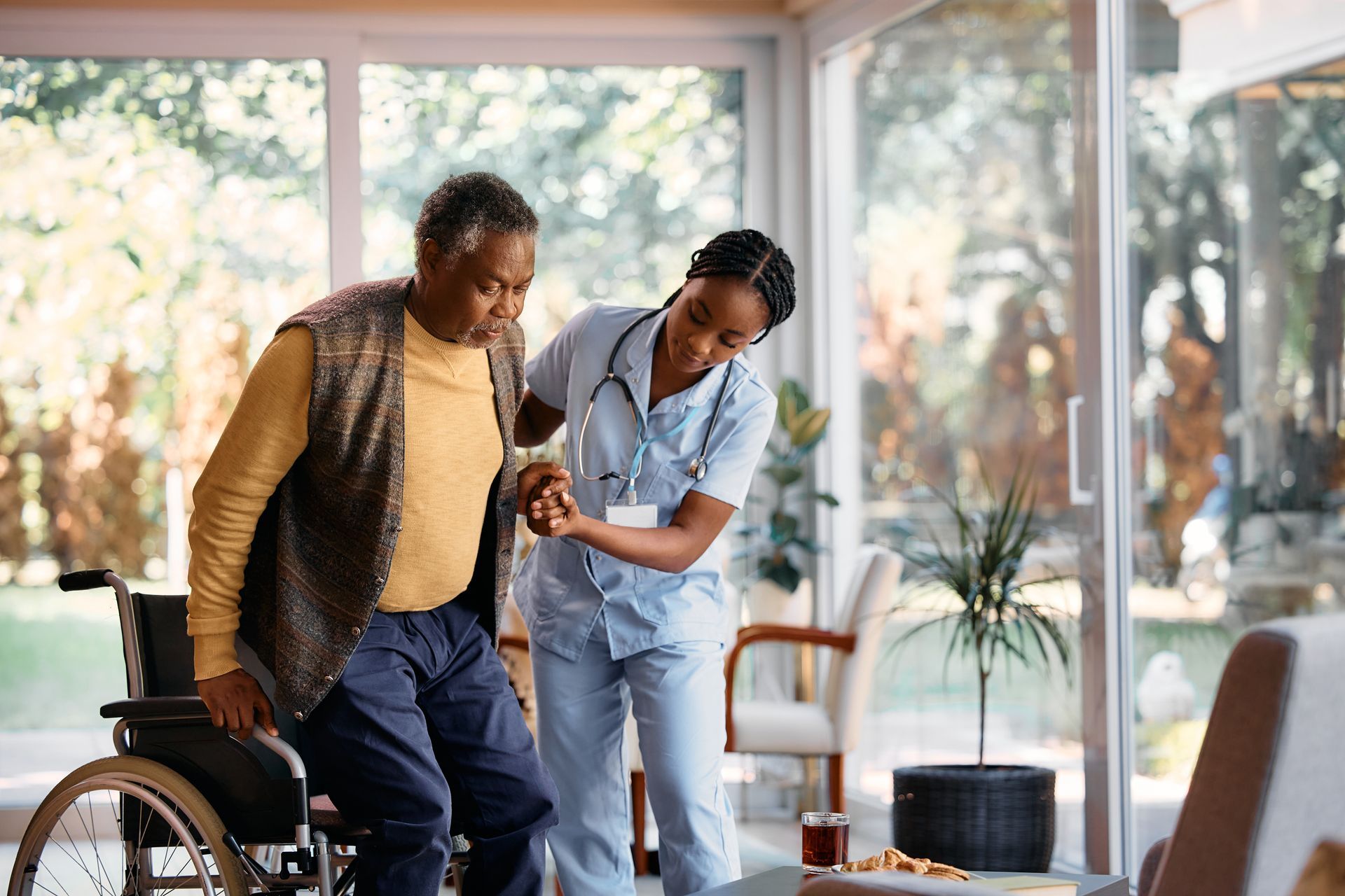 nurse helping old lady from wheelchair 