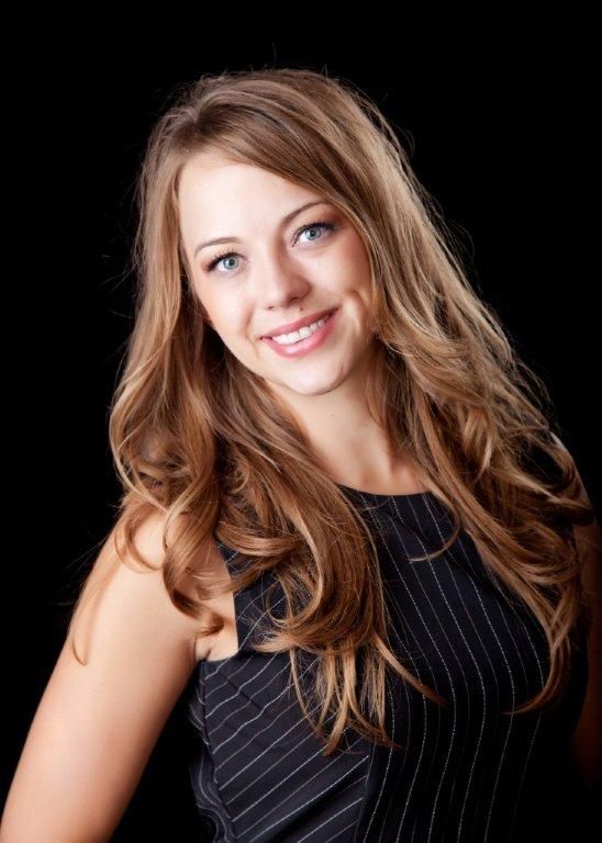 Chelsea wearing a black striped dress and smiling for the camera.