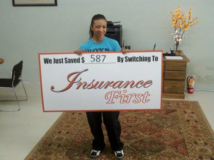 A woman holding a sign that says Insurance First