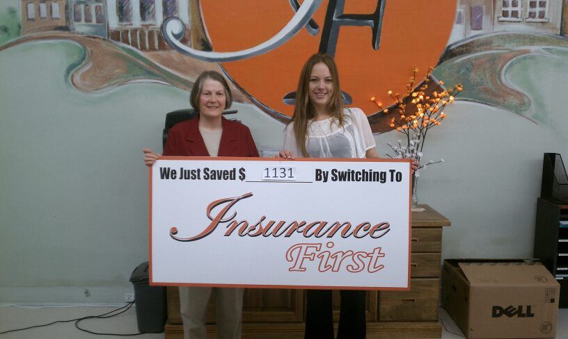Two women holding a sign that says Insurance First