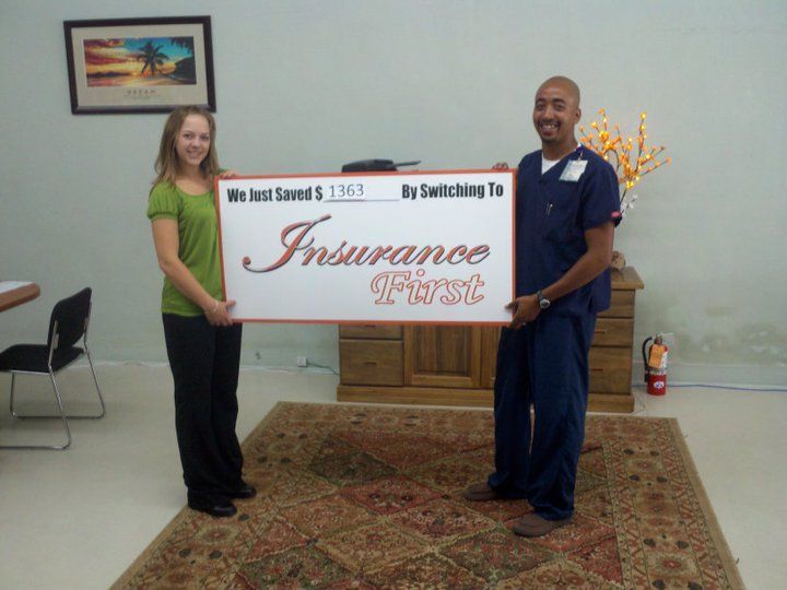A man and a woman holding a sign that says Insurance First