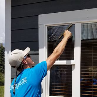man cleaning window in blue shirt