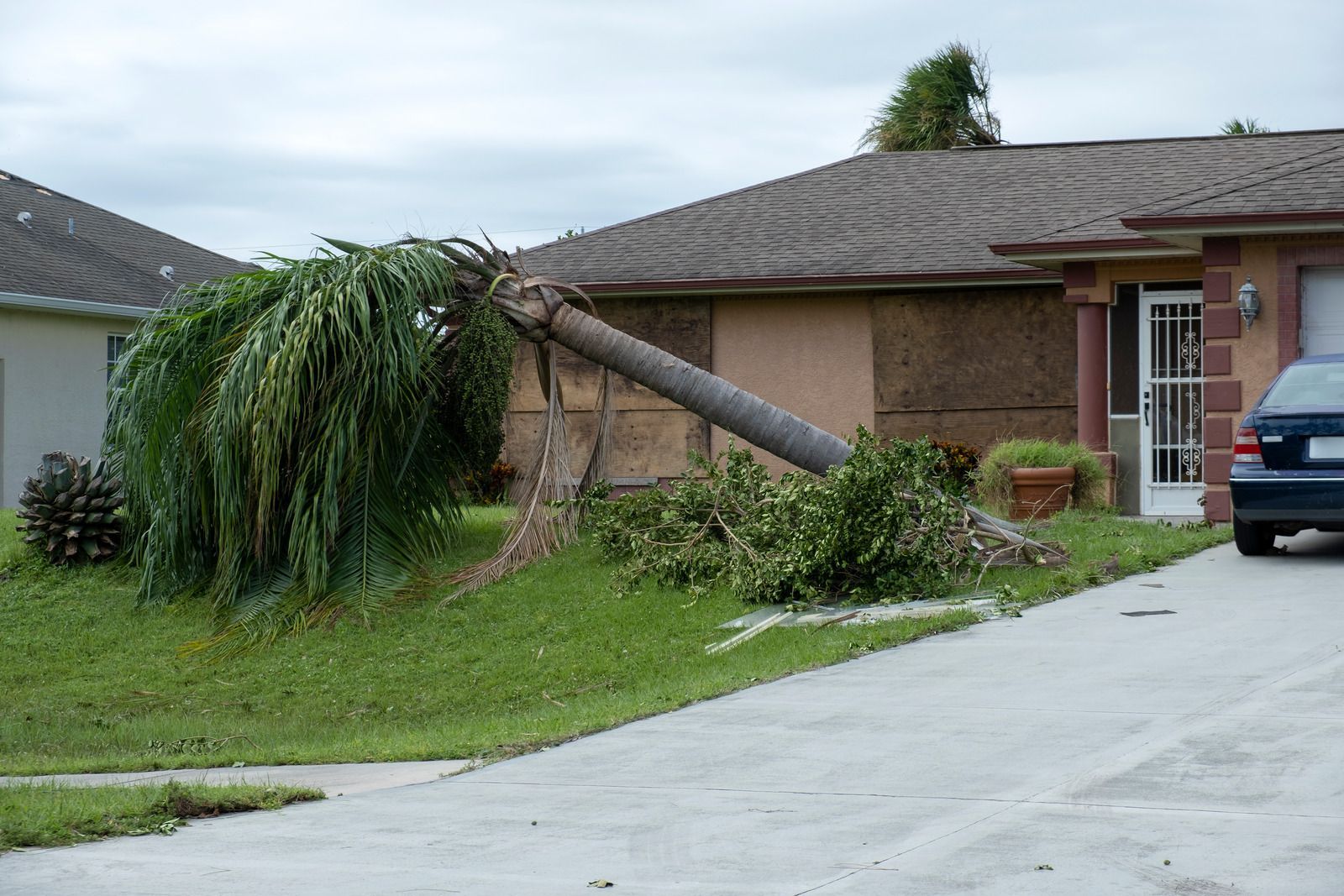 Damaged brick building roof with a large hole and exposed wooden beams after storm damage