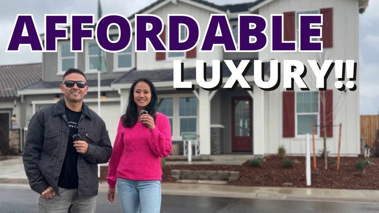 Two people stand in front of a house. Text reads