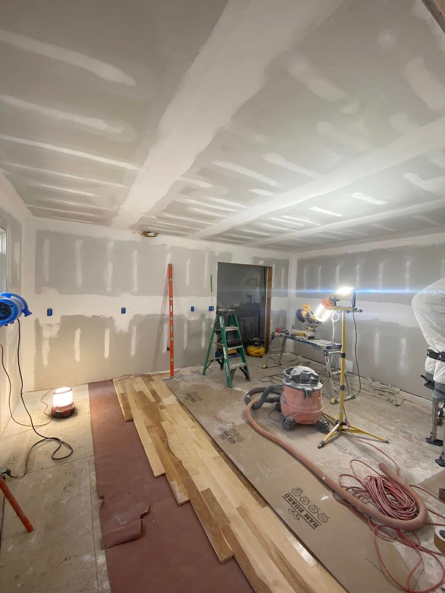 Room under construction, with drywall, flooring, and tools.