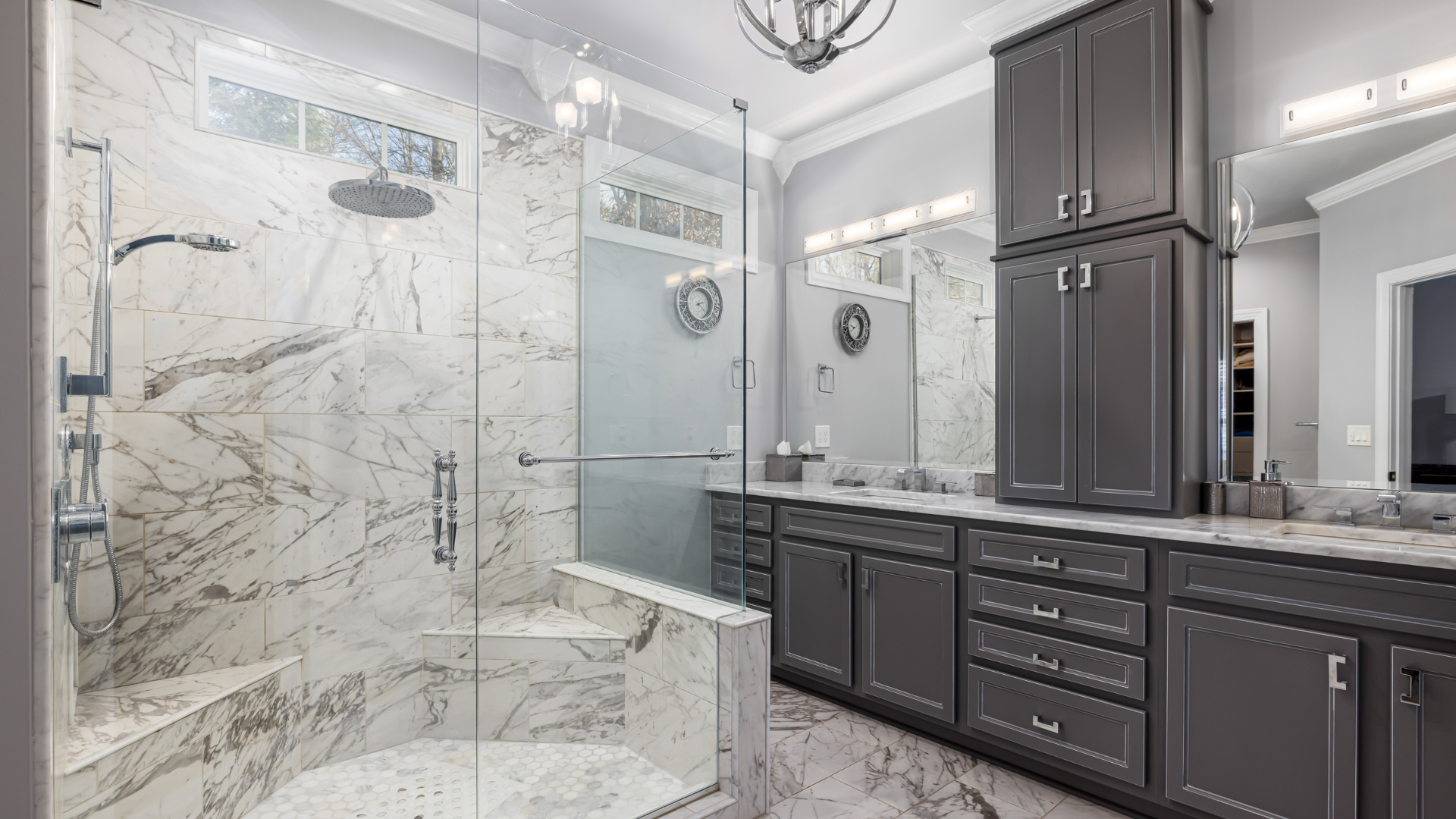 Gray and white marble bathroom with a shower, vanity, and cabinets.