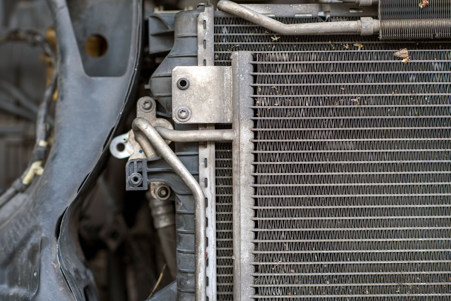 A close up of a car radiator with hose attached to it.