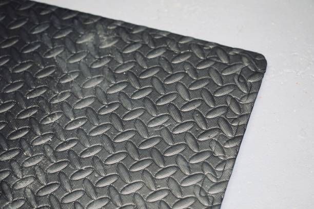 A close up of a black rubber mat with a diamond pattern on a white surface.