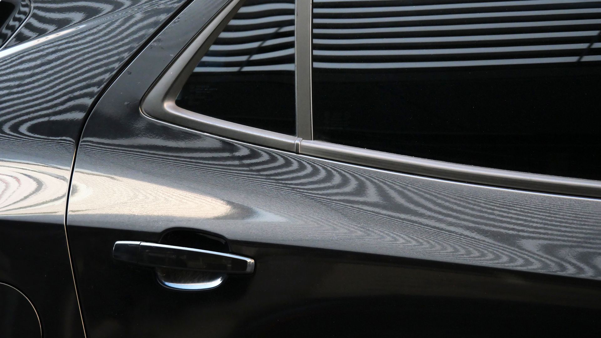 A close up of a black car 's door and window