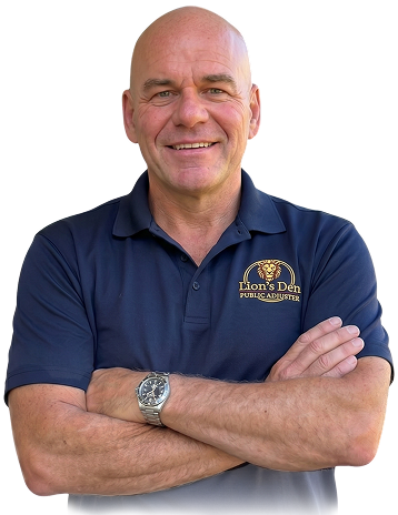 Smiling man in a navy polo shirt with arms crossed against a white background