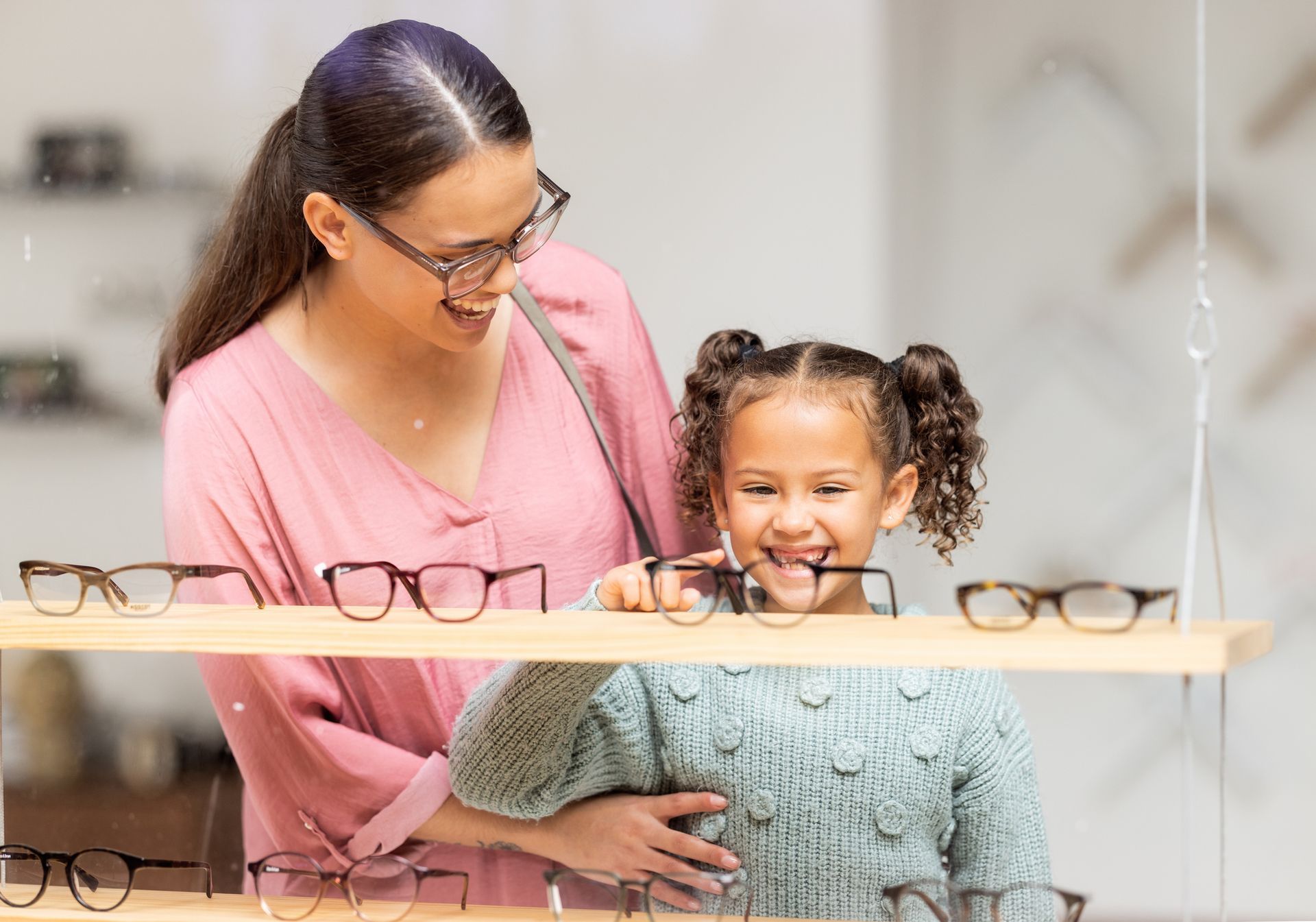 A woman and a girl examine glasses at Blue Ridge Optical in Lynchburg, VA. Shop Children's Glasses f