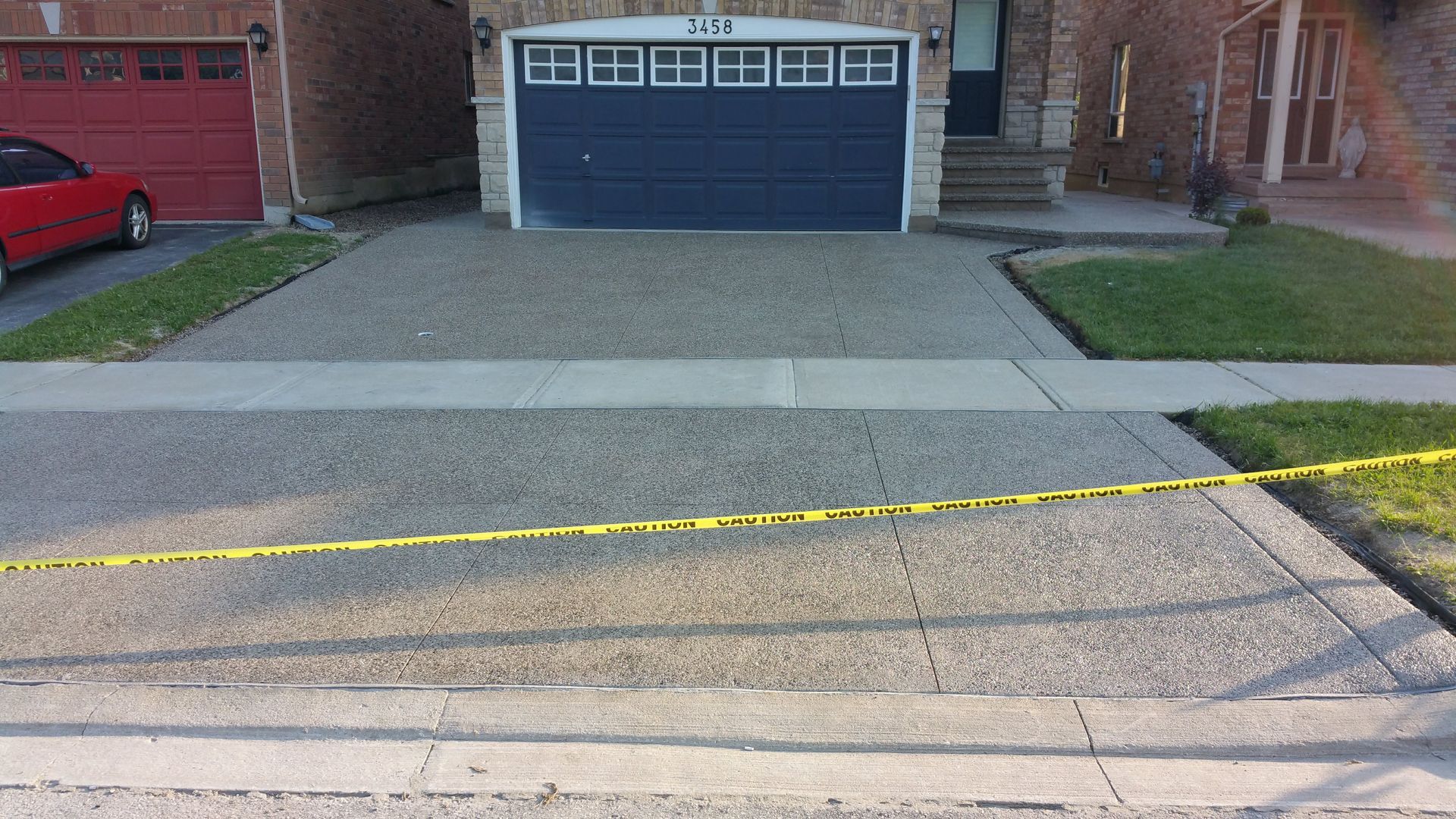A red car is parked in front of a blue garage door
