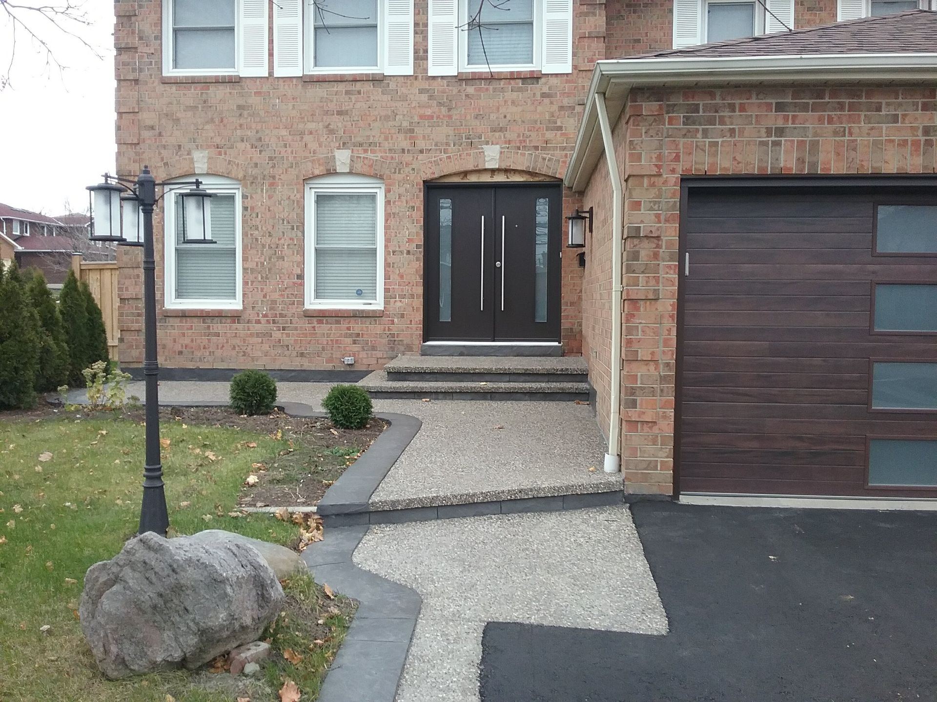 A brick house with a brown garage door