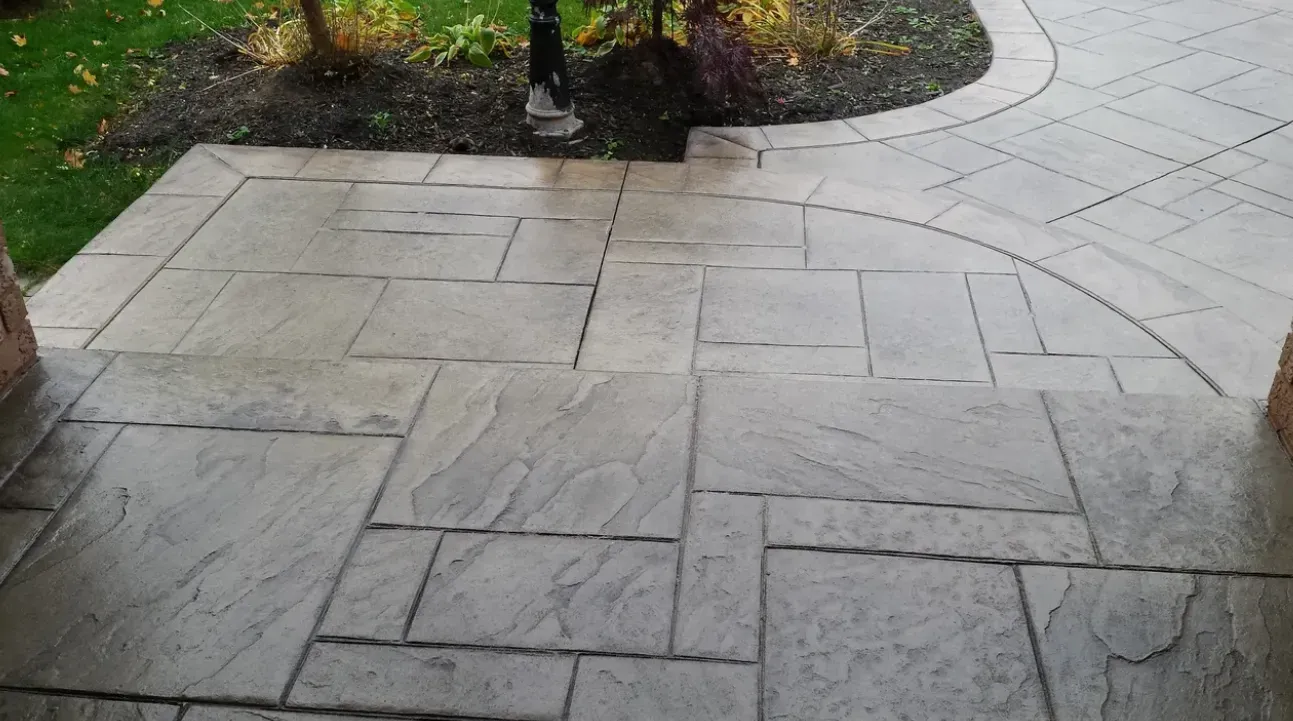A concrete walkway with steps leading up to a grassy area.