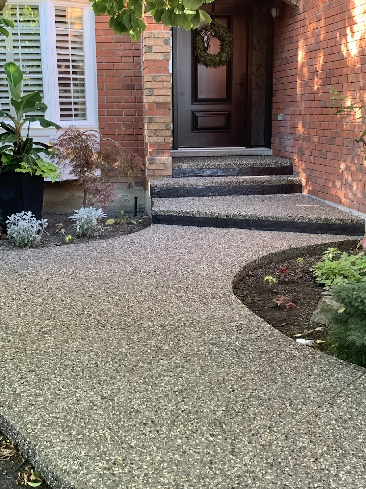 A walkway leading to the front door of a brick house.