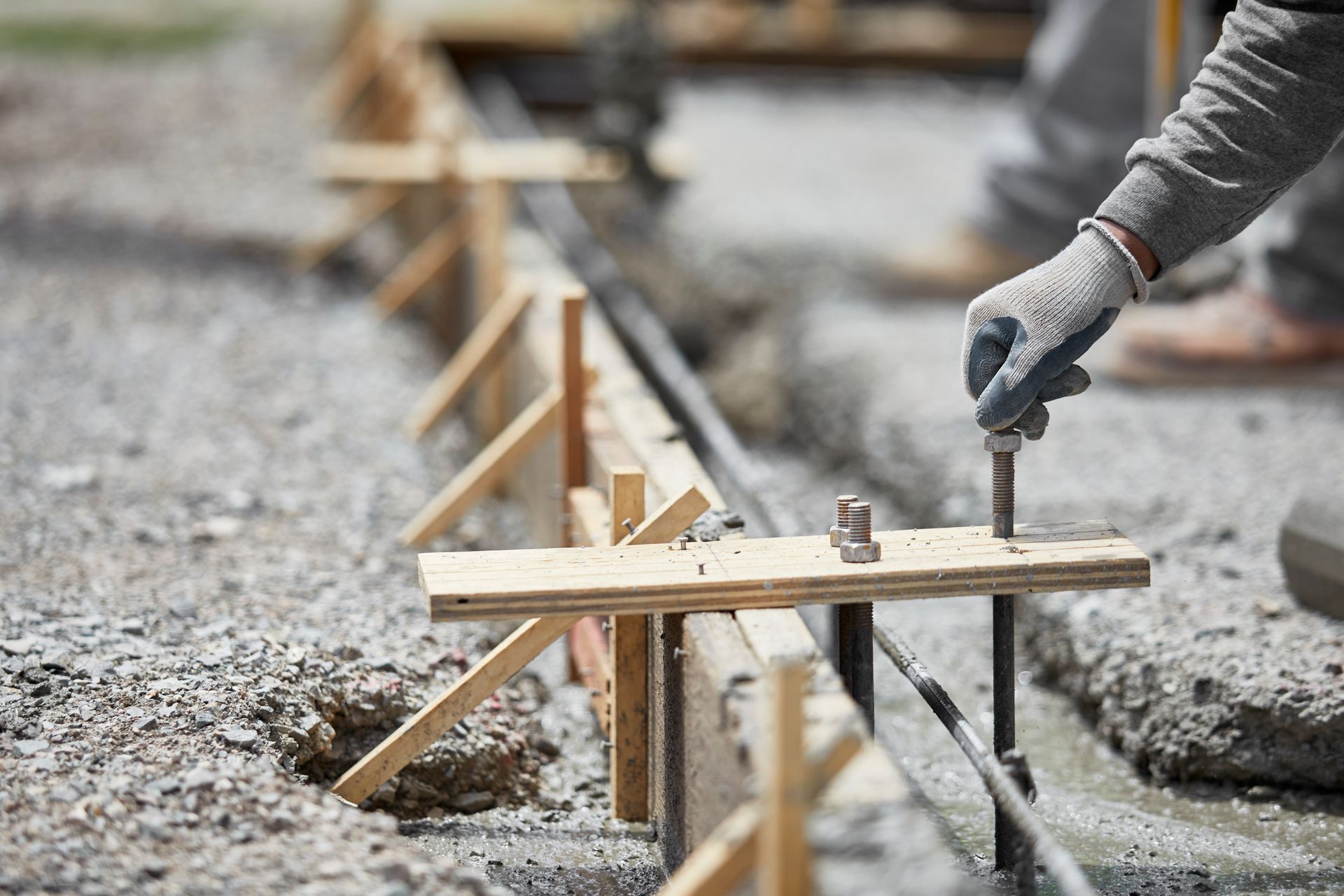 A construction worker is working on a concrete driveway.