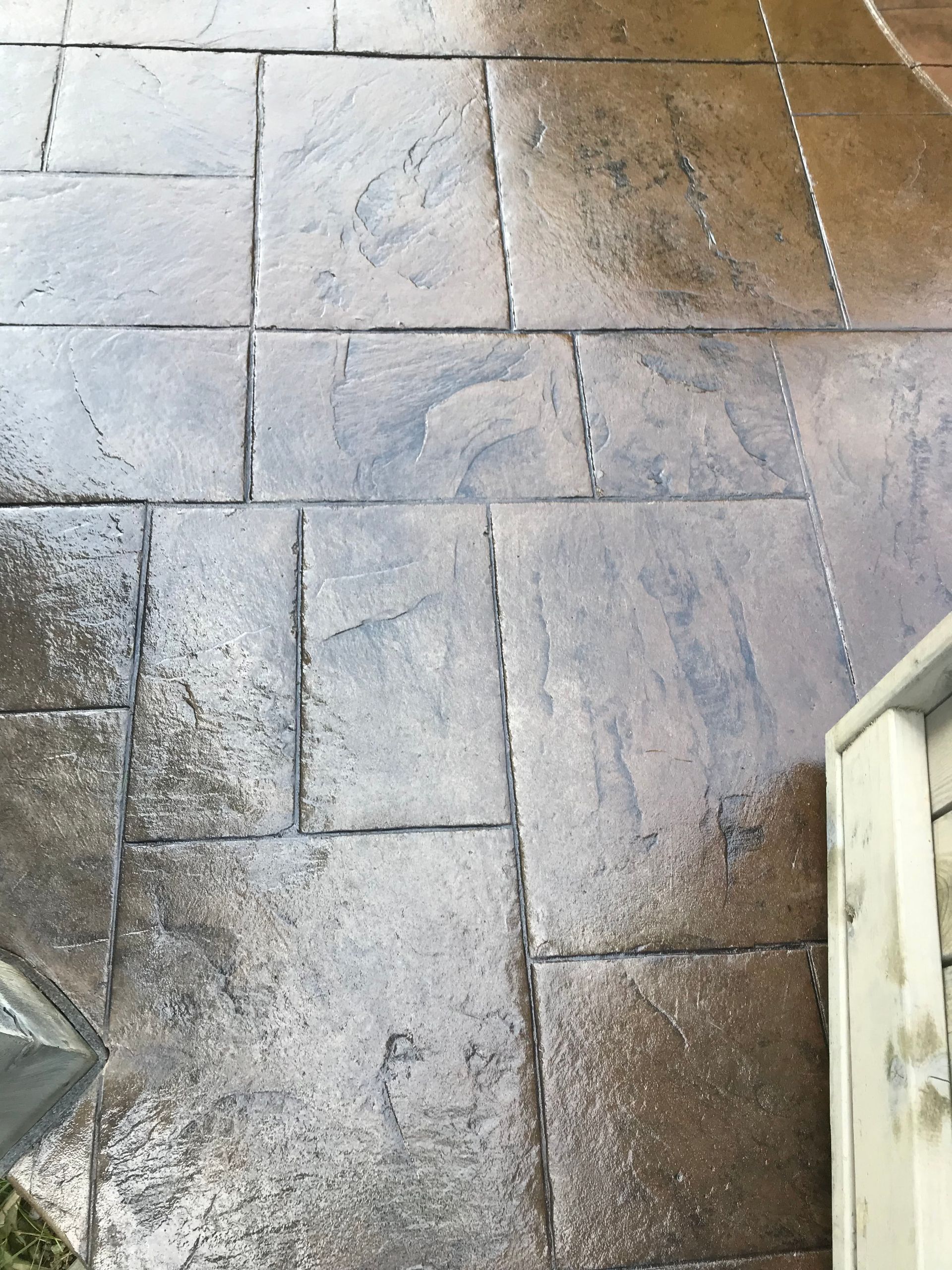 A close up of a tiled floor with a white cabinet in the background