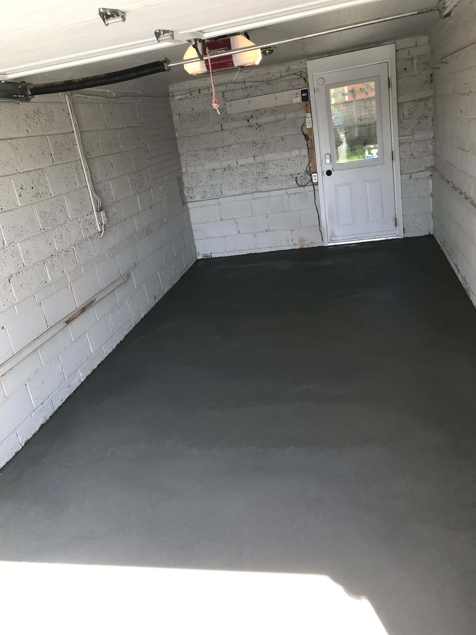 A garage with a door and a ceiling fan.