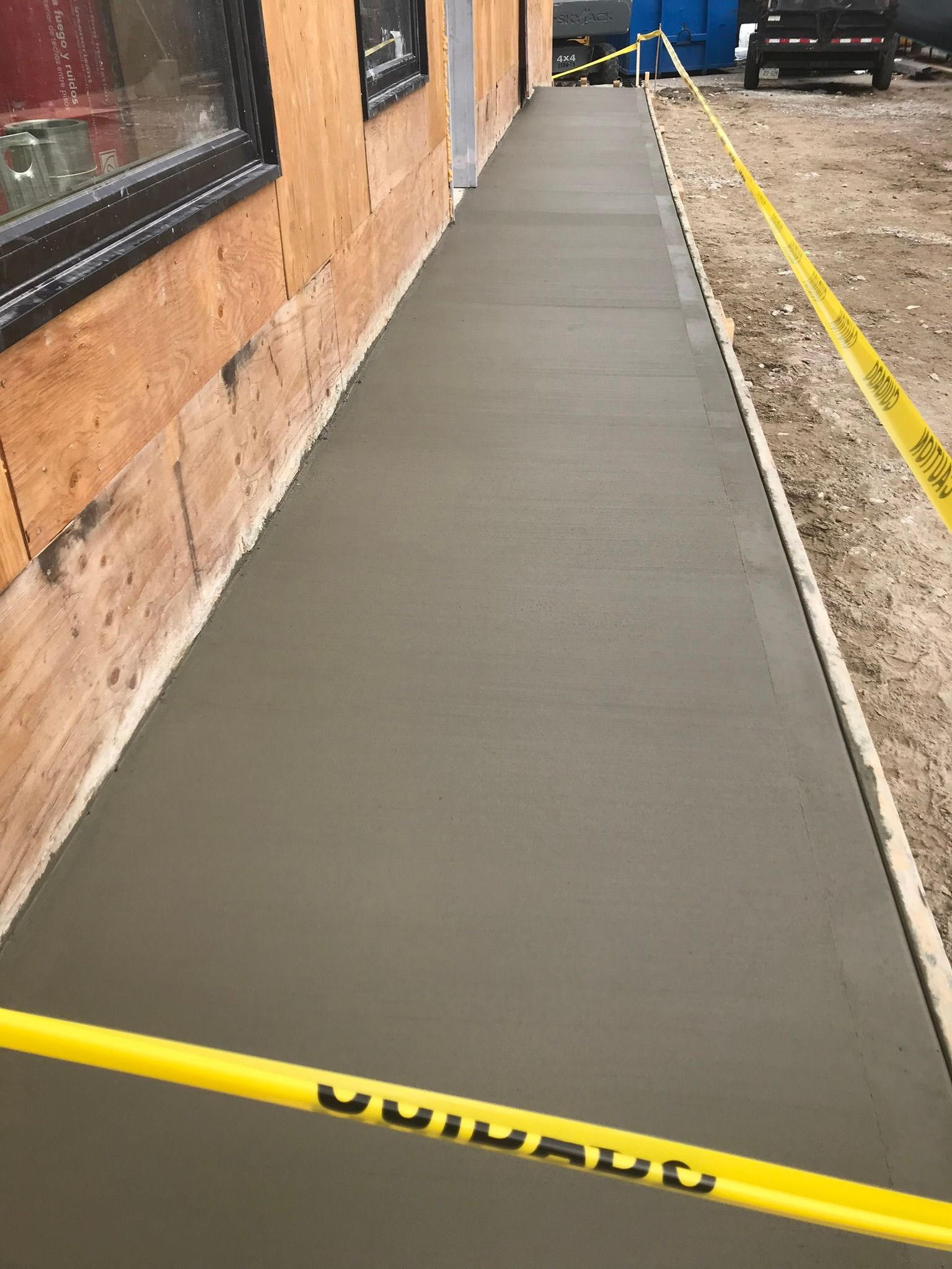 A concrete walkway is being built in front of a building.