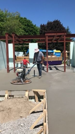 A man is using a machine to level a concrete surface