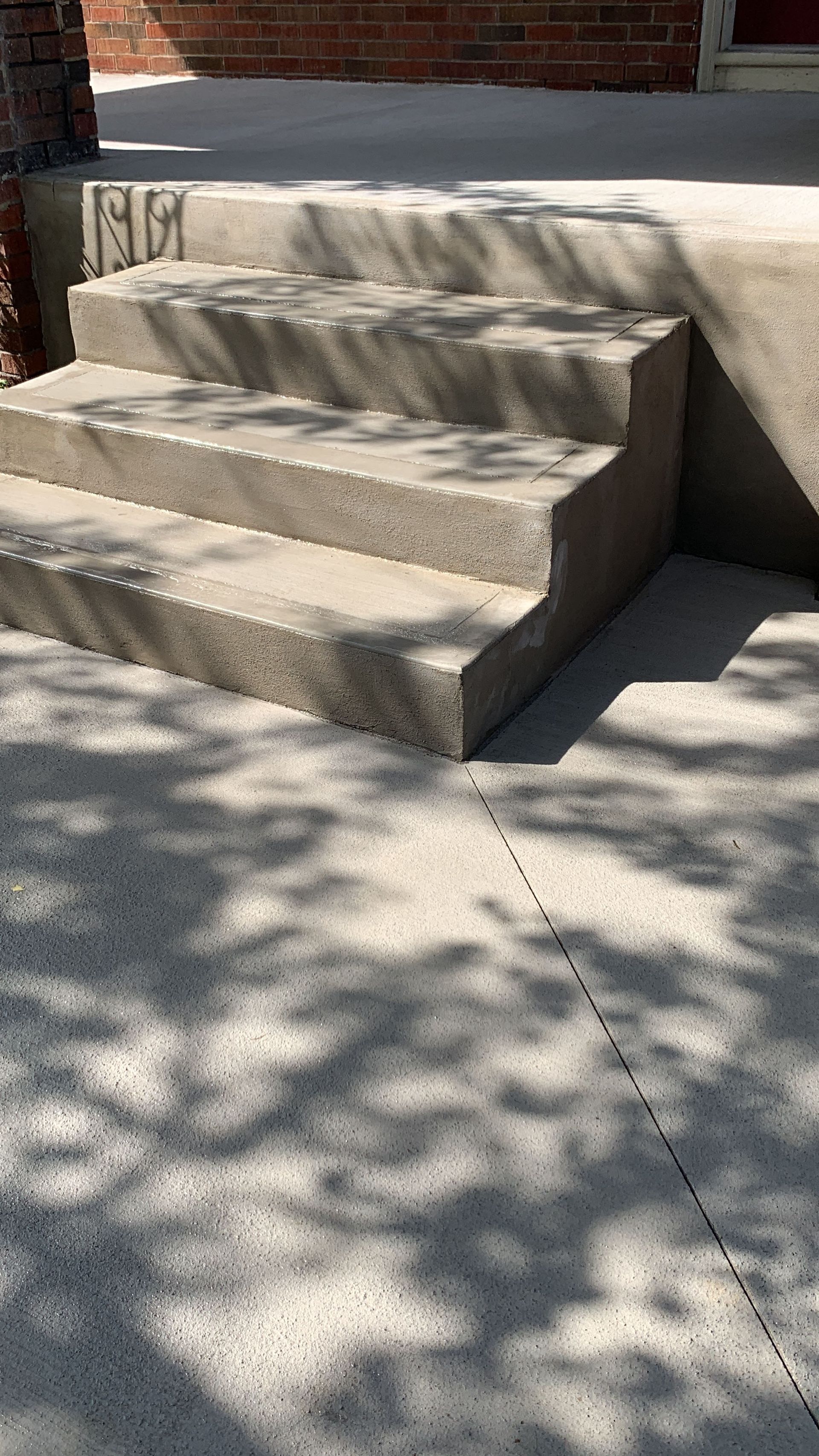 A set of concrete steps leading up to a brick building.