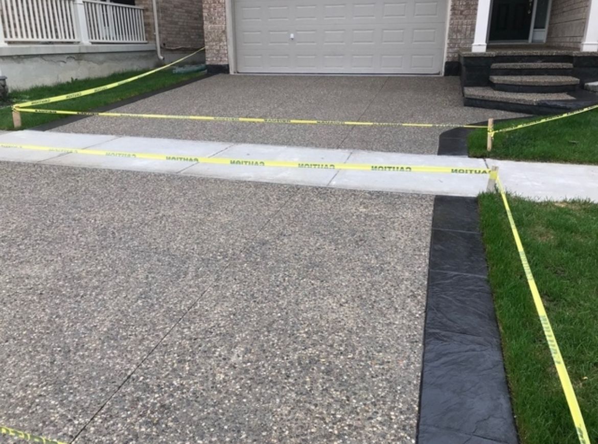 A concrete driveway is being built in front of a house.
