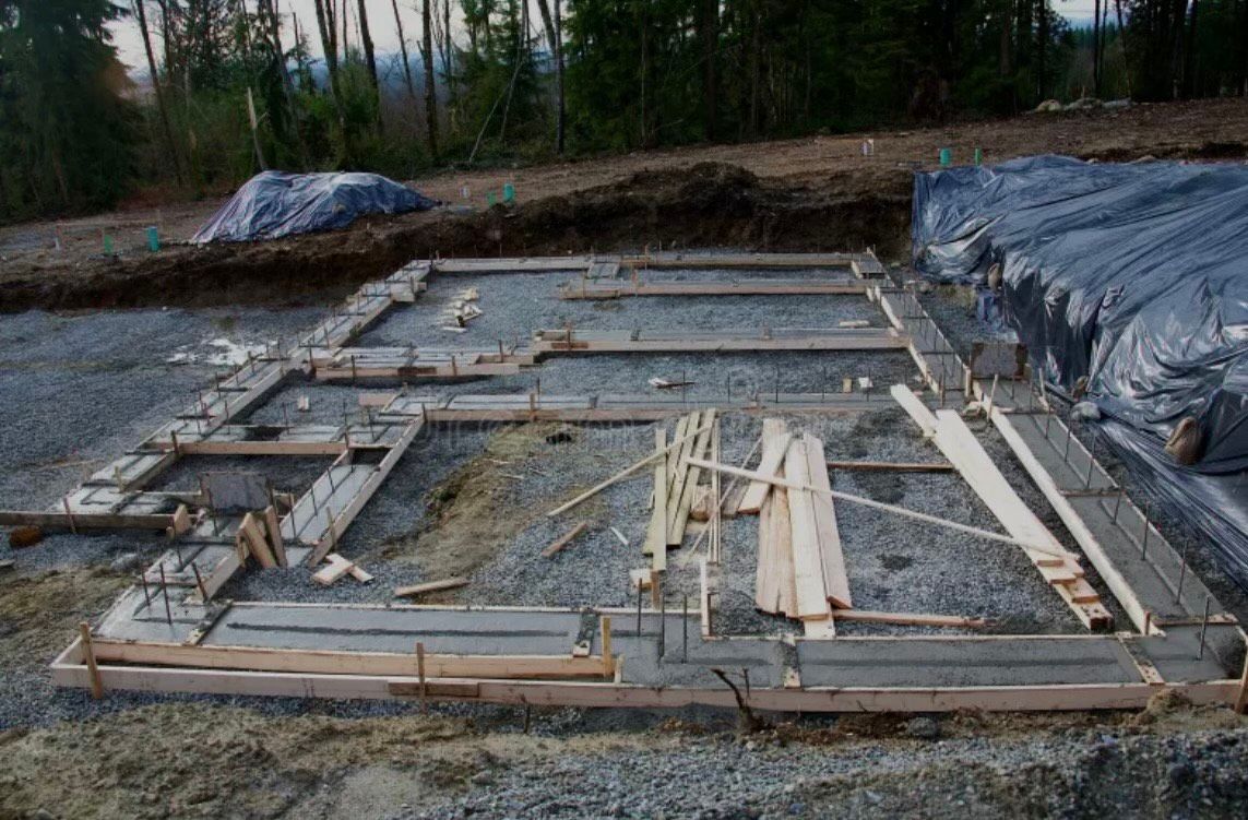 A foundation for a house is being built in the dirt.