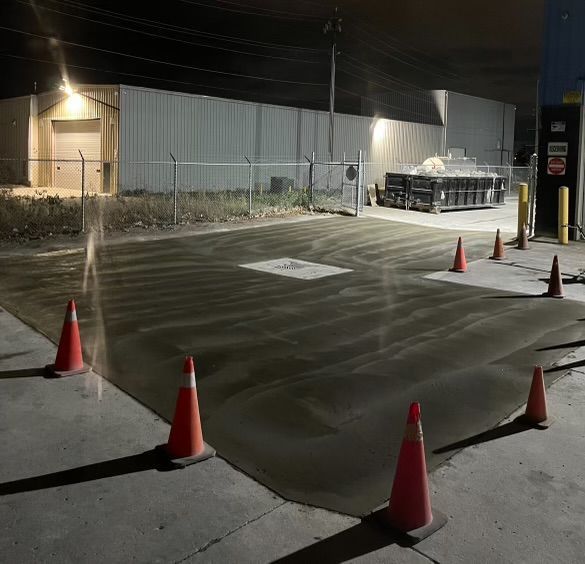 A lot of traffic cones are on the ground in a parking lot