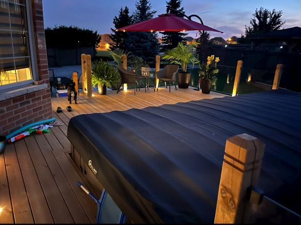 A hot tub on a deck with a red umbrella
